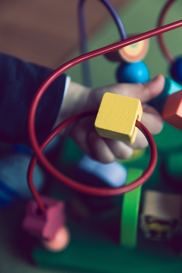 A child playing with a bead maze